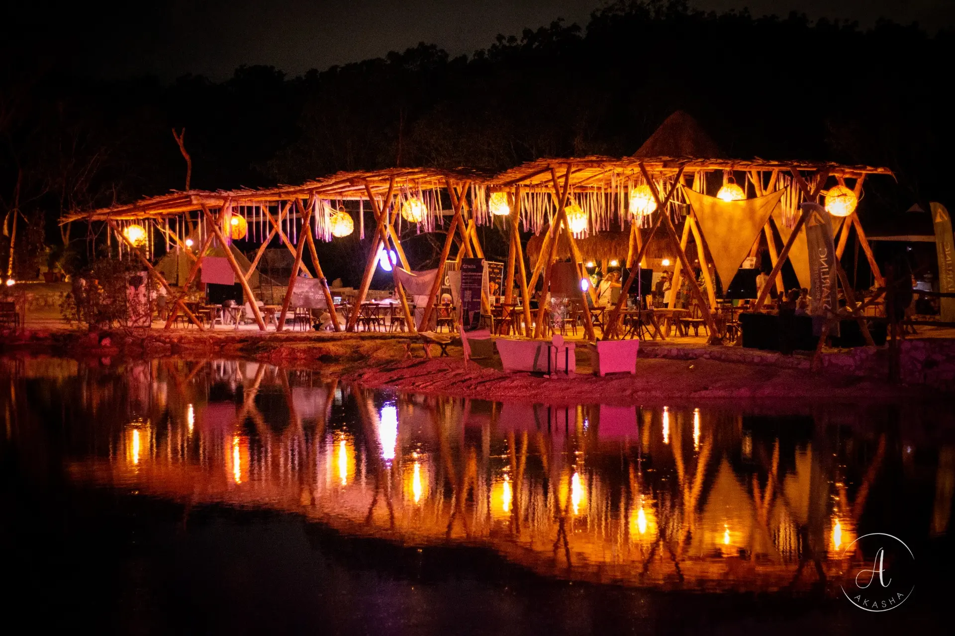Jungle venue illuminated at night beside the water